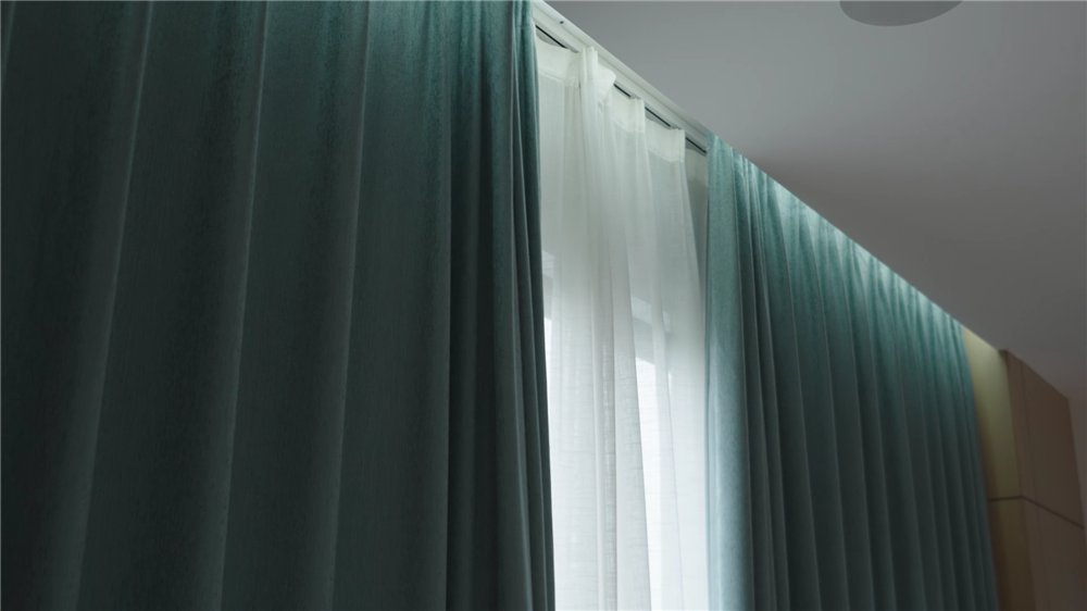 Elegant teal curtains, partially drawn, revealing sheer white curtains behind them
